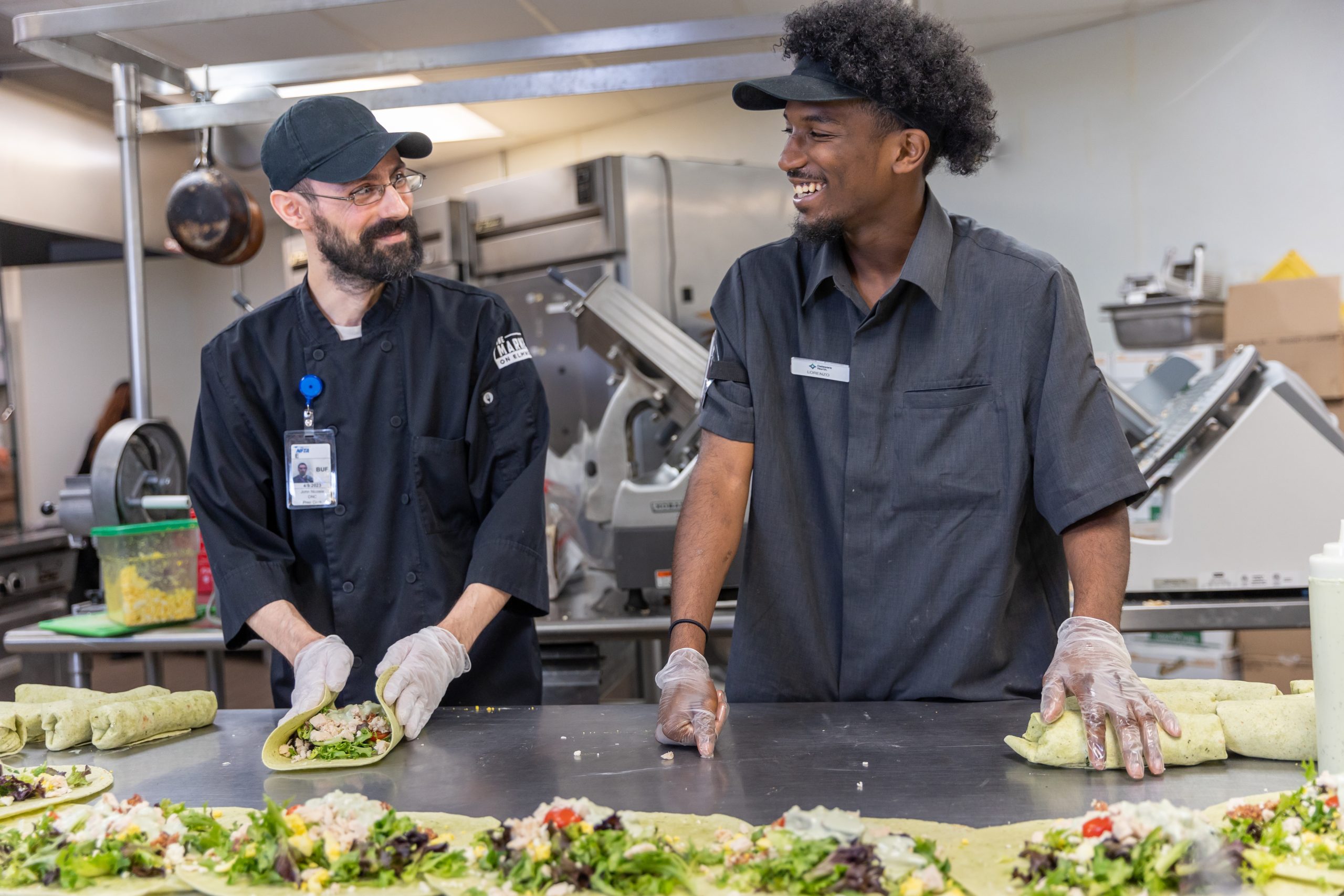Two prep cooks smiling at each other