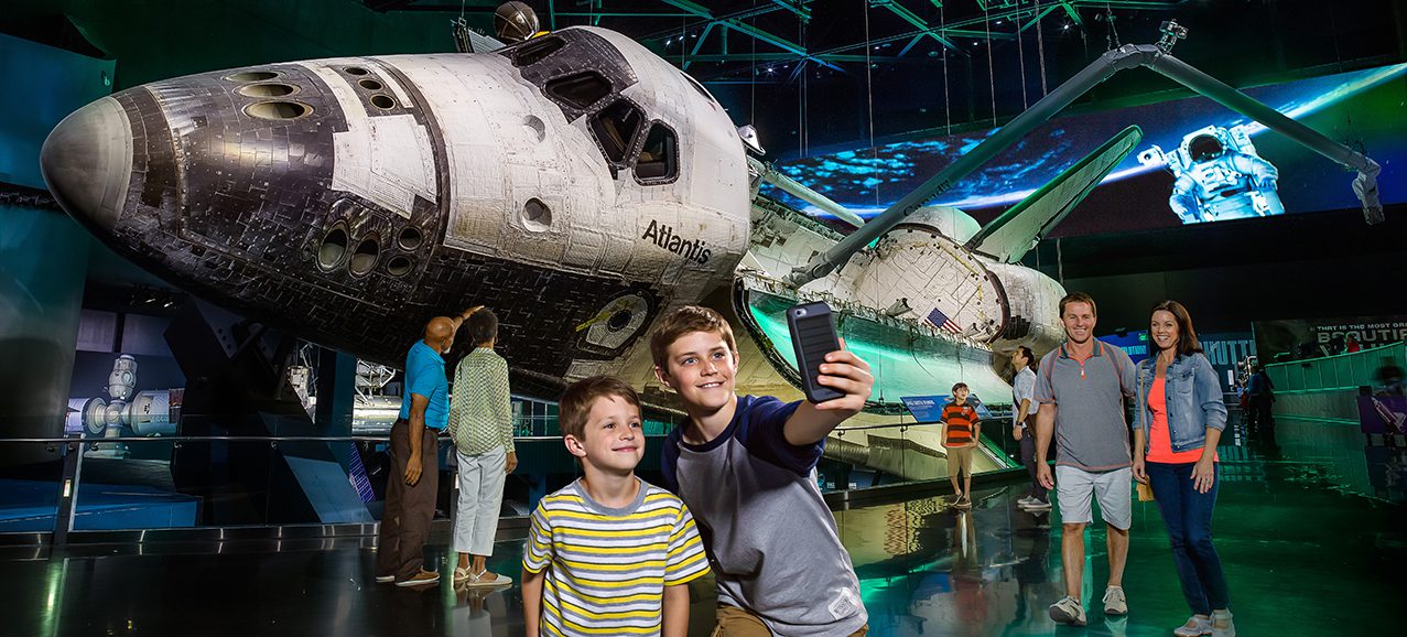 2013_A family taking a selfie in front of the NASA Space Shuttle Atlantis Exhibit at Kennedy Space Center
